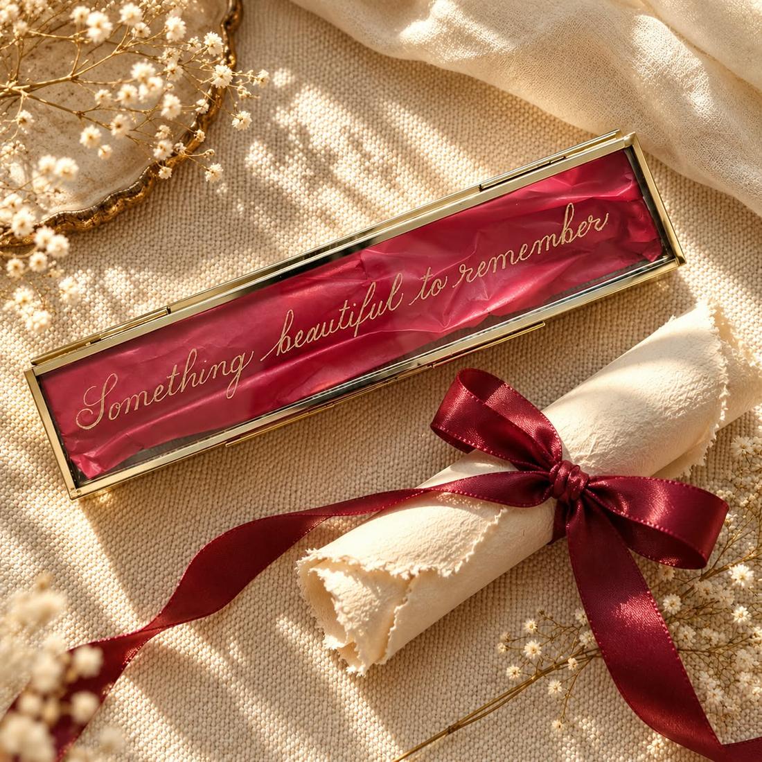 Glass keepsake box engraved with the words Something beautiful to remember, tied with a red ribbon